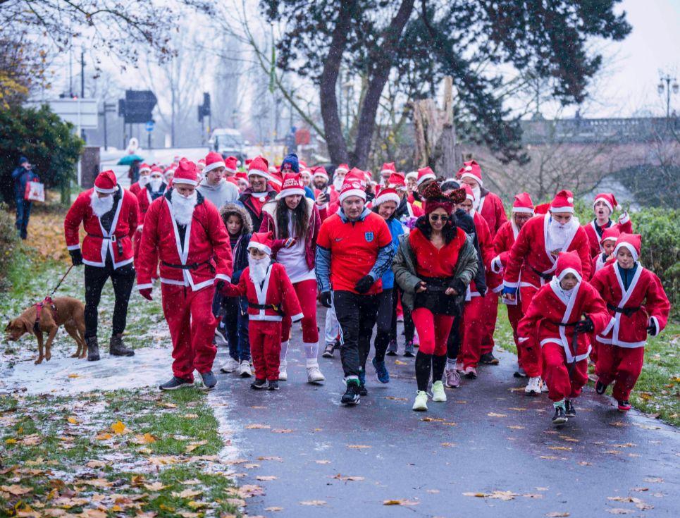 people dressed as father christmas running