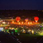 Hot air balloons lit up at night over worcester racecourse